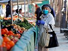 Žena s ochrannou rouškou nakupuje na zeleninovém trhu v Paříži. (19. března...