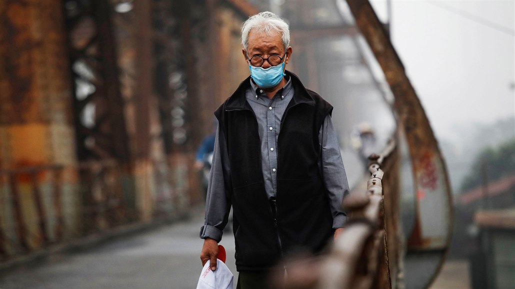 Mu s ochranou roukou prochází po most v Hanoji. (21. bezna 2020)