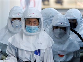 Zdravotnci z jihokorejskho Daegu v ochrannch oblecch m na specializovan...