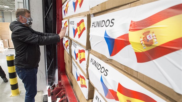 Ministr zahraničí Tomáš Petříček označuje nálepkami s českou a španělskou vlajkou krabice s humanitární pomocí. (29. března 2020)