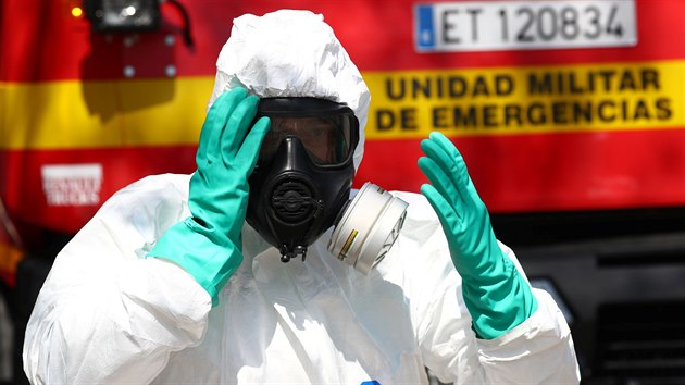 Člen španělské pohotovostní vojenské jednotky se připravuje na dezinfekci. (25. března 2020)