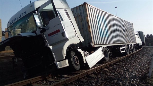 Po dopravní nehodě s osobním vlakem zůstal kamion na kolech, na kolejovém svršku.