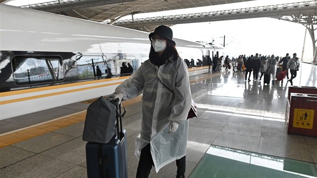 Cestujc na ndra ve Wu-chanu. Do msta, kde vypukla pandemie koronaviru, u mohou vlaky. (28. bezna 2020)