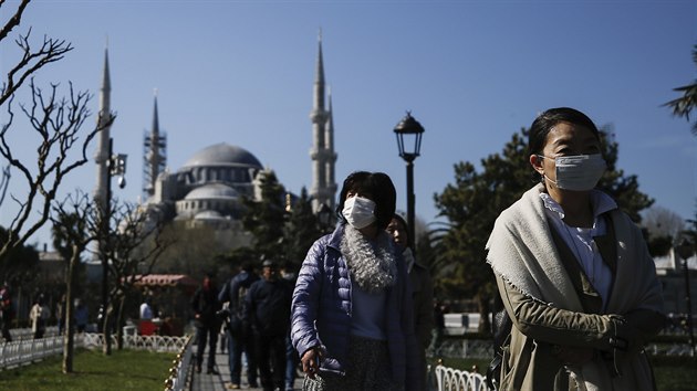 Turist s ochrannmi maskami ped Modrou meitou v Istanbulu (21. bezna 2020)