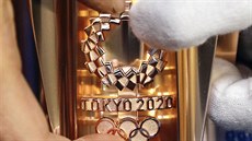 Logo olympijských her v Tokiu 2020 na pochodni s olympijským ohnm