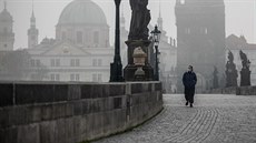Turistka prochází po oputném Karlov most v Praze. (18. bezna 2020)
