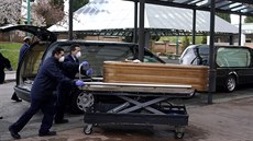 Zaměstnanci pohřební služby vezou do krematoria ostatky člověka nakaženého...