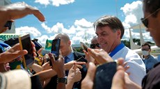 Brazilský prezident Jair Bolsonaro si podává ruce se svými píznivci navzdory...