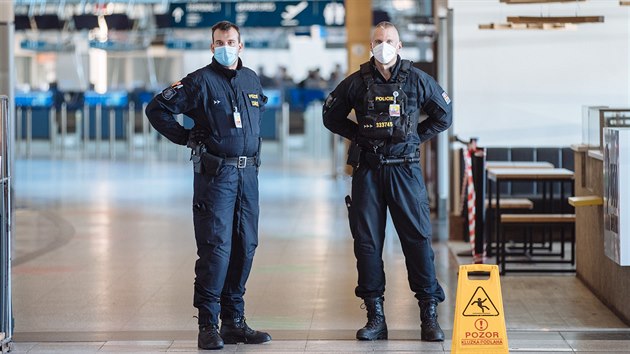 Policisté v ochranných rouškách na letišti Václava Havla v Praze (30. března 2020)