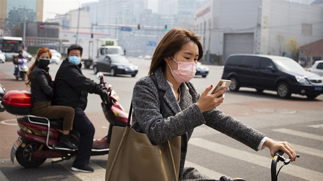 Obyvatel Pekingu se chrn roukami pi cest centrem msta. (31. bezna 2020)