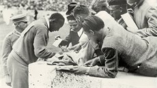 Jesse Owens se podepisuje fanou�k�m po vít�zství na stovce na olympiád� v...