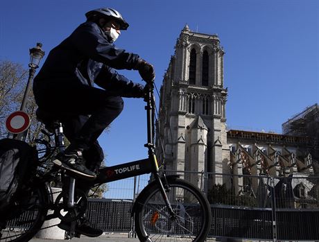 Cyklista s roukou ped paískou katedrálou Notre Dame.