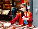 Zamstnankyn supermarketu ve Vídni dezinfikuje nákupní koíky. (1. dubna 2020)