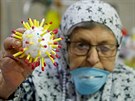 Palestinská seniorka ukazuje model koronoviru, který vyrobila v peovatelském...