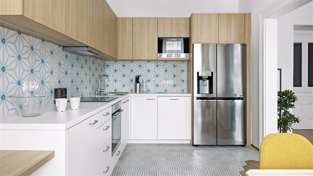 Kuchyň vyrobená na zakázku má dvířka v provedení lamino se 3D efektem dřeva. Komfort představuje americká lednice, kvalitní spotřebiče a ve skříňce vestavěná pračka.