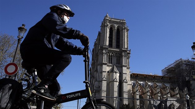 Cyklista s roukou ped paskou katedrlou Notre Dame.