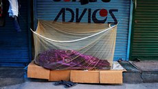 Nocleník spí vedle uzaveného obchodu uzaveného trhu v Novém Dillí. (3. dubna...
