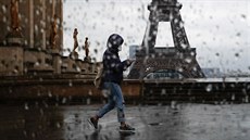 ena s roukou prochází pes námstí Trocadero v Paíi, v pozadí Eiffelova...