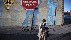Žena s maskou prochází po brooklynské ulici. (28. března 2020)