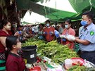Barmtí úedníci rozdávají rouky na trhu ve mst Myttha. (12. dubna 2020)