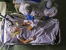 Italský léka se svým asistentem vyetuje pacienta s chorobou covid-19 na...