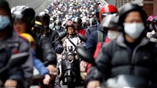 Tchajwantí motorkái ekají v dopravní zácp s roukami na oblieji. Chrání se...