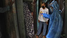 Doktor kontroluje teplotu dívky v jednom z nejvtích asijských slum Dharavi v...