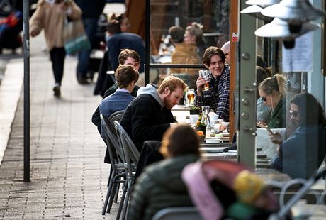 Lidé popíjí ve stockholmské kavárn. (20. dubna 2020)