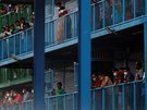 Zahraniní pracovníci shlíejí z balkón ubytoven pro migranty v Singapuru. V...