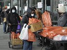 Dobrovolníci Potravinové banky v Brooklynu podávají balíky zájemcm. (24....