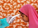 Zdravotník kontroluje teplotu pákistánské dívce v Karáí. (21. dubna 2020)
