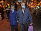 Seniorský pár s roukami prochází trhem v Barcelon. (29. dubna 2020)