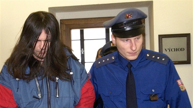 Příslušník justiční stráže přivádí trojnásobného vraha Jaroslava Gančarčíka na jednání Krajského soudu v Praze. (18. ledna 2005)