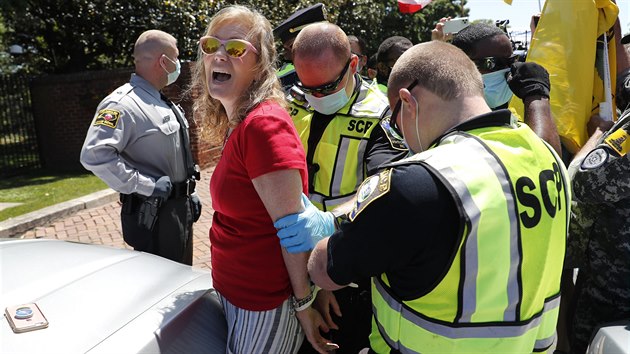 Policie zadržuje členku skupiny protestující proti koronavirovým omezením v Severní Karolíně. Vůdkyně skupiny přiznala, že měla pozitivní testy na koronavirus. (28. dubna 2020)
