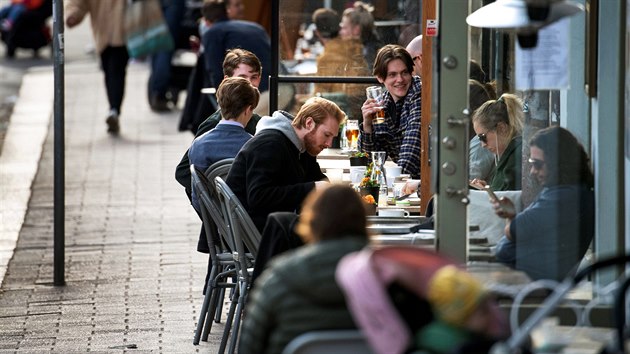 Lidé popíjí ve stockholmské kavárně. (20. dubna 2020)
