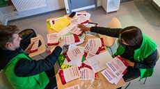 Teenagei najatí obcí Jakobsberg rozdávají místním lidem informaní letáky v...
