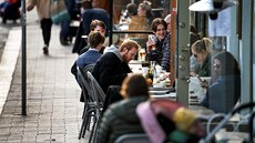 Lidé popíjí ve stockholmské kavárn. (20. dubna 2020)