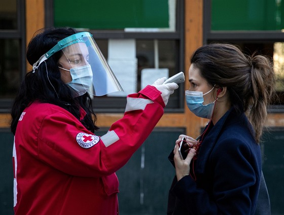 Dobrovolnice Červeného kříže kontroluje teplotu ženy v Athénách v Řecku. (30....