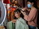 Zákaznice obchodu s módou v ínské provincii Chu-nan si nechává upravit vlasy....