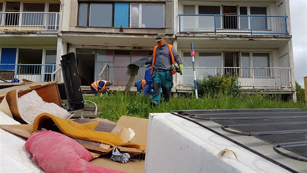 Před demolicí vybydleného panelového domu v Janově je nejprve potřeba vyklidit tuny odpadu nashromážděného zdejšími obyvateli. (29. dubna 2020)