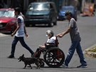 Mu tlaí enu na invalidním vozíku pes ulici ve tvrti Iztapalapa v Mexico...