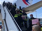 Policisté spolen s hasii pi vykládce posledního letadla z íny se...