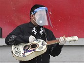 Ekvádorští hudebníci zvaní mariachi vystupují v ulicích Quita s rouškami a...