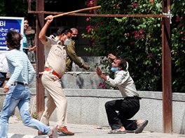 Indick policista bije mue, kter ve front ped vinotkou v Novm Dill...
