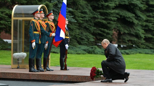 Rusk prezident Vladimir Putin na zatku krtkho proslovu poklekl na koleno ped pamtnkem neznmho vojna pod ervenmi zdmi Kremlu a sloil k nmu kytici ervench r. (9. kvtna 2020)