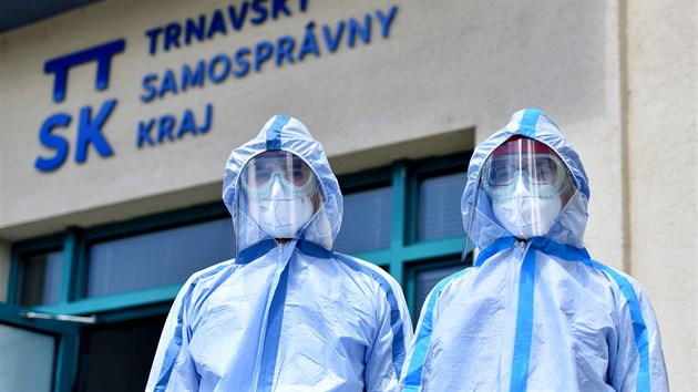 Dobrovolnci v ochrannch oblecch pi tiskov konferenci ve slovensk Trnav, kde pedstavili mobiln jednotku k odebrn vzork na testovn koronaviru u rizikovch a imobilnch pacient. (5. kvtna 2020)