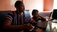 Matka s dcerou sledují online výuku bhem karantény kvli koronaviru v...