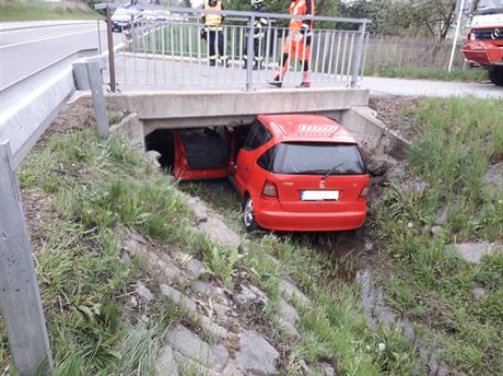 Automobil napasovaný pod mostem.
