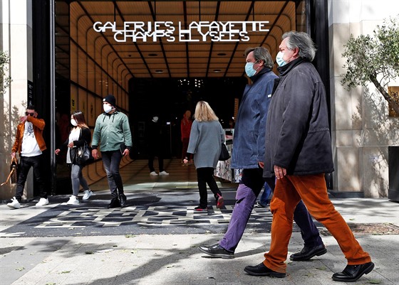 Lidé v rouškách prochází po nákupní třídě Champs-Élysées v Paříži. (11. května...