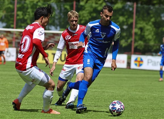 Pardubičtí fotbalisté Sanghyeok Lee a Emil Tischler (vzadu) nahánějí  Václava...